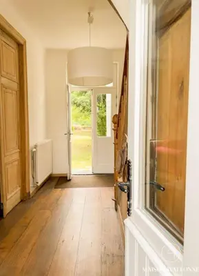 a hallway with a door and a wooden floor at La maison de Maître - Grand Jardin, Face à la Meuse in Hermalle-sous-Argenteau