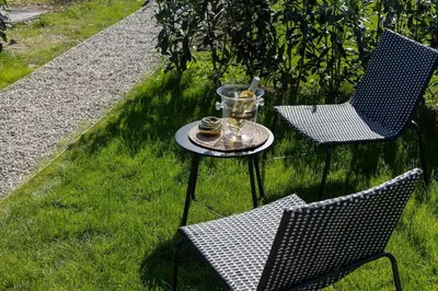 two chairs and a table with a tray on the grass at le Bellessa Gite de luxe pour 2 personnes in Basse Tribomont