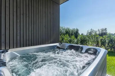 a hot tub in a backyard with water in it at le Bellessa Gite de luxe pour 2 personnes in Basse Tribomont