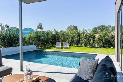 a swimming pool in a backyard with a table and chairs at Lodge 4 you gite de luxe pour 4 personnes in Verviers