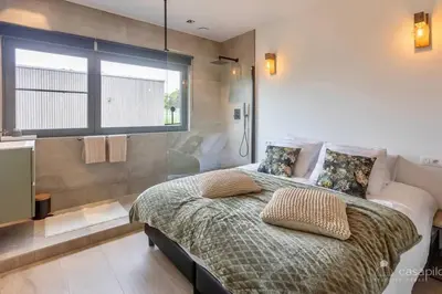 a bedroom with a bed and a large window at Lodge 4 you gite de luxe pour 4 personnes in Verviers