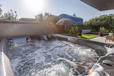 a hot tub in a backyard with an umbrella at Gite SIWA pour 2 personnes in Verviers