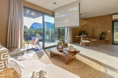 a living room with a large screen on the wall at Gite SIWA pour 2 personnes in Verviers