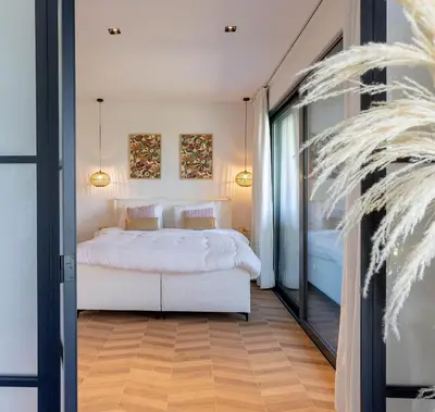 a bedroom with a white bed and a large mirror at Gite Olea de deux personnes in Basse Tribomont