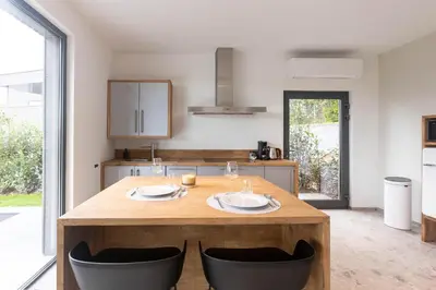 a kitchen with a wooden table with two plates on it at Gite Olea de deux personnes in Basse Tribomont