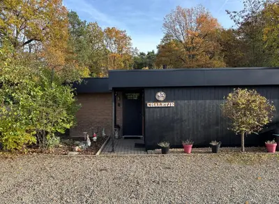 a black building with a sign on the door at Vakantiehuis chaletje in Lanaken
