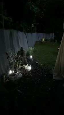 a backyard at night with lights in the grass at Vakantiehuis chaletje in Lanaken