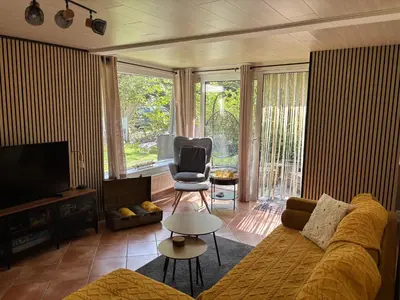 a living room with a couch and a chair at Vakantiehuis chaletje in Lanaken