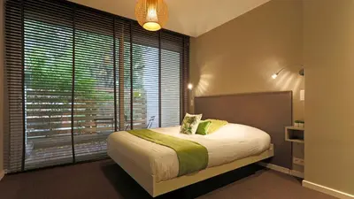 a bedroom with a large bed and a large window at Aparthotel Liège in Liège