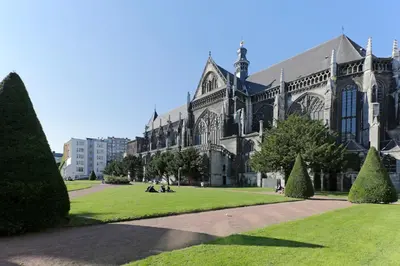 a large cathedral with people sitting on the grass in front at Aparthotel Liège in Liège
