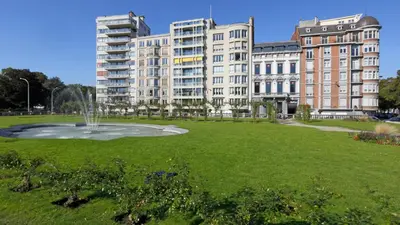a park with a fountain in front of some buildings at Aparthotel Liège in Liège