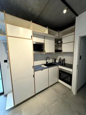 a small kitchen with white cabinets and a sink at lOFT 202 in Liège