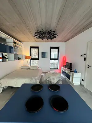 a bedroom with a large bed with a blue table at lOFT 202 in Liège