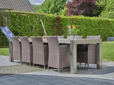 a table with wicker chairs and a table with flowers on it at Bigaro 1 in Heers