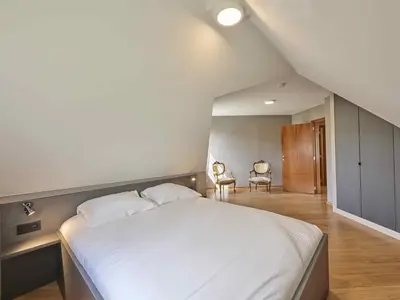 a bedroom with a large white bed and two chairs at Bigaro 1 in Heers