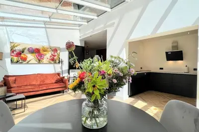 a vase of flowers on a table in a living room at Vakantiewoning De Merode in Lanaken
