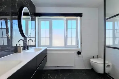 a bathroom with a sink and a toilet and a window at Vakantiewoning De Merode in Lanaken