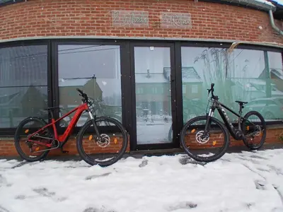 two bikes parked in front of a building in the snow at Vakantiehuis 2 Wheels 2 Relax in Wellen
