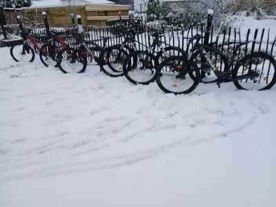 a row of bikes parked next to a fence in the snow at Vakantiehuis 2 Wheels 2 Relax in Wellen