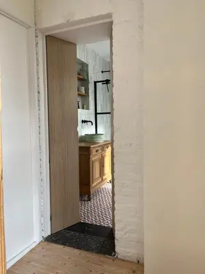 a bathroom with a wooden vanity and a sink at Vakantiewoning de Toren in Kortessem