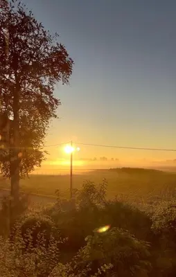 a sunset over a field with a street light at Vakantiewoning de Toren in Kortessem