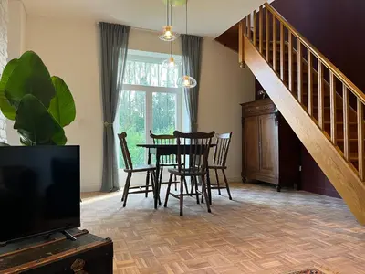 a living room with a table and chairs and a tv at Vakantiewoning de Toren in Kortessem