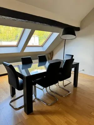 a dining room with a black table and chairs at Lovely loft for romantic getaway or family trip in Chaudfontaine