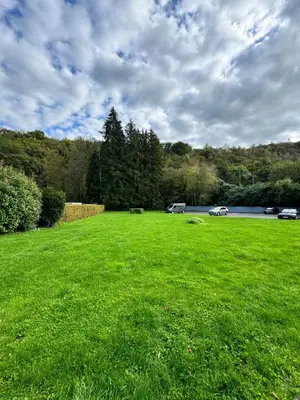 a field of green grass with cars parked in it at Lovely loft for romantic getaway or family trip in Chaudfontaine