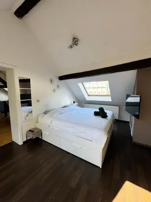 a bedroom with a white bed and a window at Lovely loft for romantic getaway or family trip in Chaudfontaine