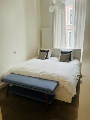 a bed in a room with a window at Louvrex 78 in Liège