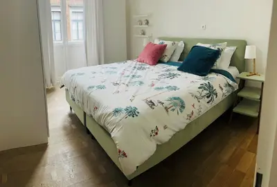 a bed with colorful pillows on it in a bedroom at Louvrex 78 in Liège