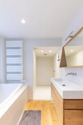 a white kitchen with a sink and a bath tub at Louvrex 78 in Liège