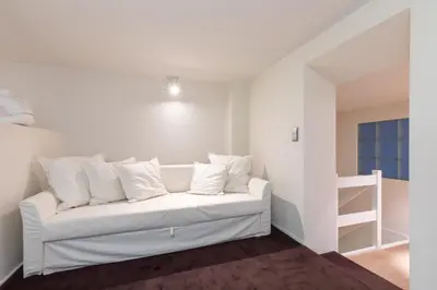 a white couch with white pillows in a room at Louvrex 78 in Liège