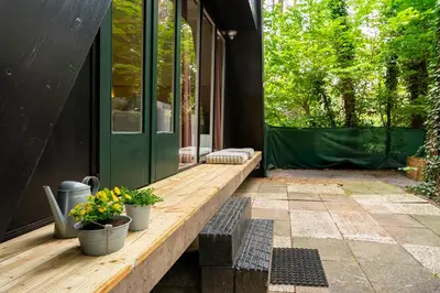 a porch of a house with two potted plants on it at Boshuisje Rekem - Memories in Lanaken