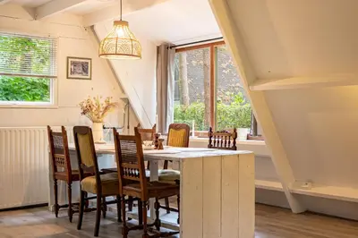 a dining room with a table and chairs at Boshuisje Rekem - Memories in Lanaken