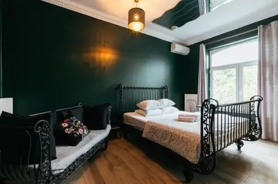 a bedroom with two beds and a green wall at Hotel Riad Nour in Liège