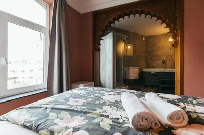 a bedroom with a bed and a large mirror at Hotel Riad Nour in Liège