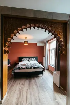 a bedroom with a bed with an arch over it at Hotel Riad Nour in Liège