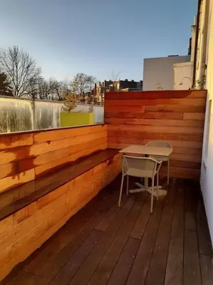 a table and a chair on a wooden balcony at Atelier 27, Duplex with terrace and beautiful view in Liège