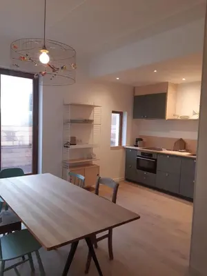 a kitchen and dining room with a wooden table and chairs at Atelier 27, Duplex with terrace and beautiful view in Liège