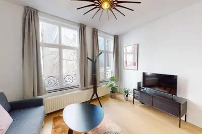 a living room with a blue couch and a television at House W 35 in Liège
