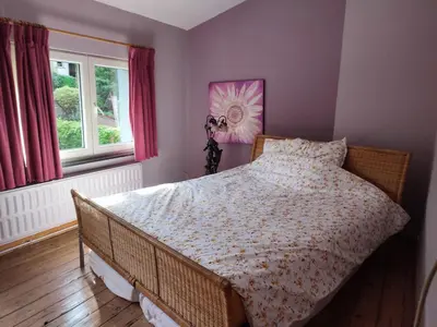 a bedroom with a bed with a comforter and a window at Chez Marie in Liège