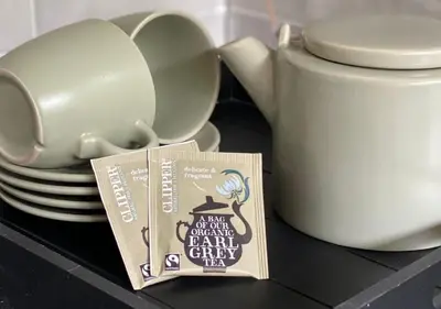 a tea pot and a book next to a stack of plates at Eekhoorn-huisje, 4-pers bungalow, Rekem in Lanaken