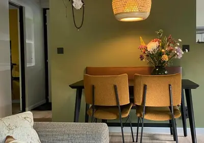 a dining room table with chairs and a vase of flowers at Eekhoorn-huisje, 4-pers bungalow, Rekem in Lanaken