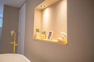 a bathroom with a tub and a shelf with vases at Wellnesshuisje Pocono cabin in Lanaken