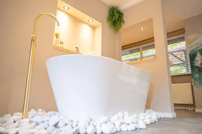 a bathroom with a white tub with white balls on the floor at Wellnesshuisje Pocono cabin in Lanaken