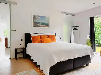 a bedroom with a large bed with orange pillows at 8P 4B Lanaken Retreat: Swimming Pool Jacuzzi and Sauna in Lanaken