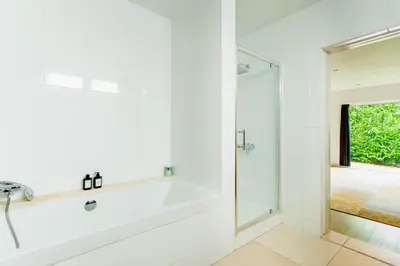 a white bathroom with a tub and a shower at 8P 4B Lanaken Retreat: Swimming Pool Jacuzzi and Sauna in Lanaken
