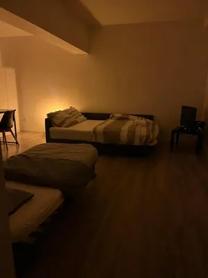 a room with two beds and a laptop on a table at Superbe studio à Liège in Saint-Léonard