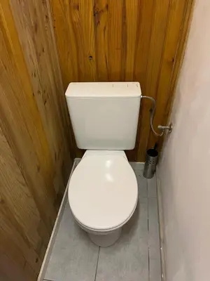 a white toilet in a bathroom with wooden walls at Superbe studio à Liège in Saint-Léonard